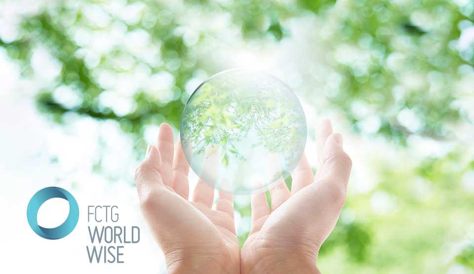 Hands holding a glass orb with trees in the background